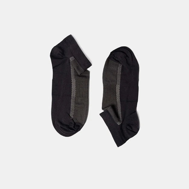 A pair of low-cut black and dark gray socks with a ribbed texture, laid flat on a plain light gray background.