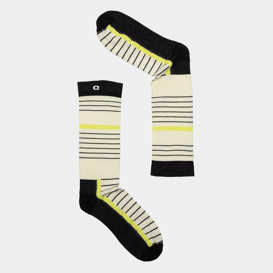 Two knee-high socks with horizontal black stripes, yellow accents, and black heels and toes are arranged to form the shape of the letter L on a plain white background.