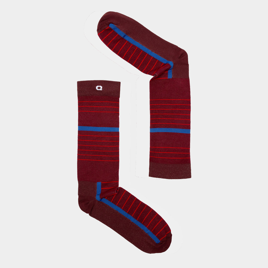 Two maroon socks with red and blue horizontal stripes are arranged on a white background to form the shape of the number 1.