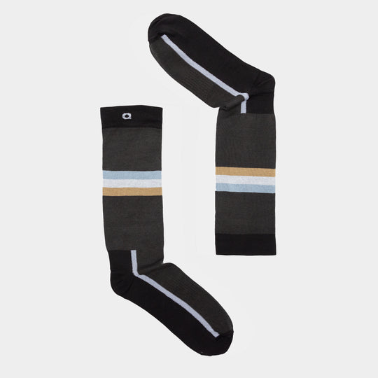 Two dark gray socks with black toes and heels, each featuring a horizontal light blue and tan stripe near the top, are arranged on a white background to form the shape of the number 7.
