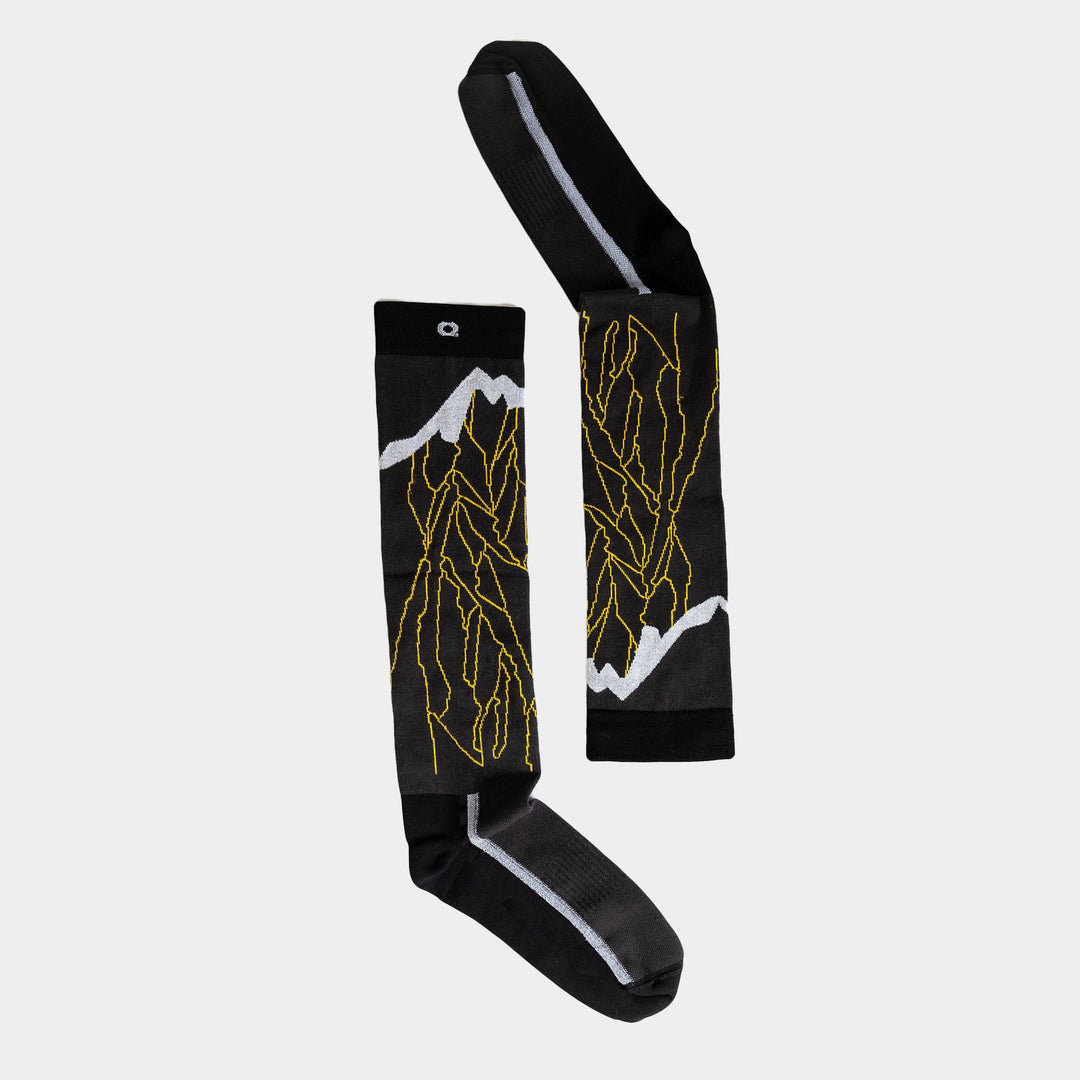 A pair of black knee-high socks with yellow lightning bolt patterns and white accents, laid flat on a light gray background.