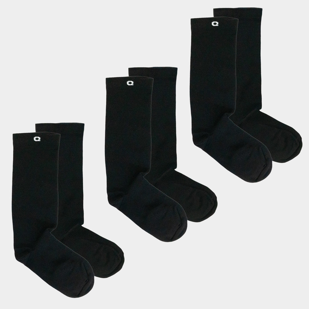 Three pairs of plain black crew socks with a small white logo near the top, arranged side by side on a white background.