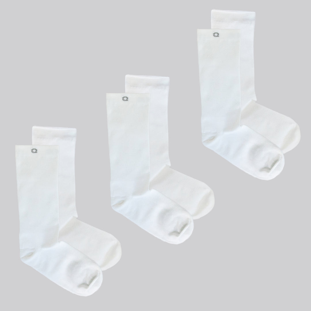 Three pairs of plain white crew socks are displayed on a light gray background, arranged side by side, each pair stacked with one sock slightly overlapping the other.