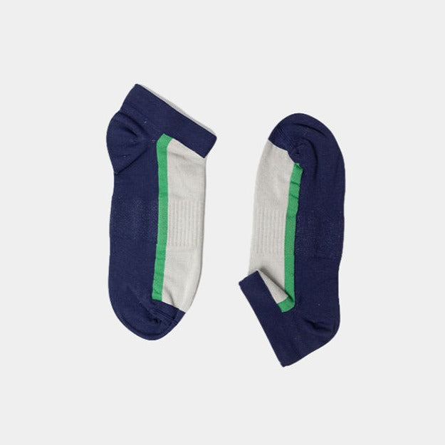 A pair of ankle socks with navy blue toes, heels, and cuffs, white midsections, and a green stripe running along each side, displayed on a plain light background.