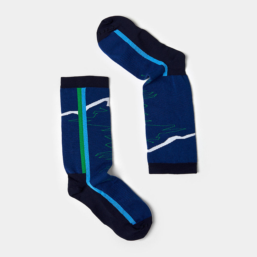 A pair of blue crew socks featuring navy toes, heels, and cuffs, with a green stripe and a white zigzag pattern resembling a mountain range on the sides. The socks are laid flat against a light gray background.